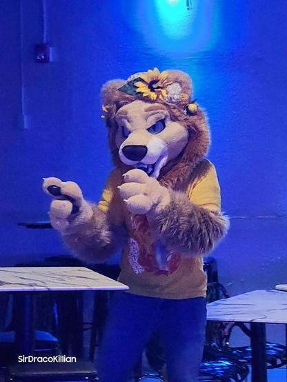 Ado the lion singing next to some tables at a bar. It's karaoke night and he's doing Shinedown - Simple Man