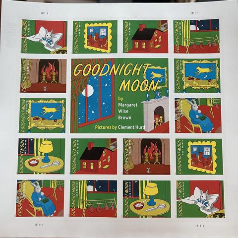 This photo displays a sheet of U.S. postage stamps commemorating the beloved children's book "Goodnight Moon" by Margaret Wise Brown, with pictures by Clement Hurd.

The sheet features a large central block and multiple individual stamps arranged around it.

The central block is a vibrant depiction of the iconic "Goodnight Moon" book cover, showing a dark room with a large window looking out at a crescent moon and stars, and a cozy red and yellow striped curtain. The title "GOODNIGHT MOON" is p…