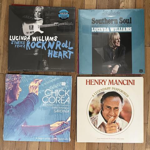 This image shows four album covers.

Lucinda Williams - "Stories From A Rock N Roll Heart" (newly released as indicated by a sticker on the plastic wrap).

Lucinda Williams - "This Time Jukebox - Southern Soul: From Memphis To Muscle Shoals & More".

Chick Corea & Orchestra da Camera Della Sardegna - "A Night of Mozart & Gershwin".

Henry Mancini - "A Legendary Performer".

