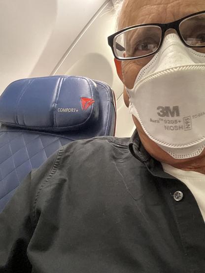 masked selfie seared on a plane