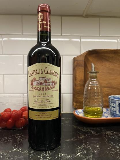 This photo shows a classic Bordeaux wine displayed on a kitchen counter.

The Wine:
Château de Corneurs

2021 Bordeaux Supérieur

Grand Vin de Bordeaux (estate-bottled wine)

Appellation Bordeaux Supérieur Contrôlée

The Blend:
75% Merlot
20% Cabernet Sauvignon
5% Cabernet Franc

Producer:
Vignobles Fabris
10 Rue de l'Abbé Berdey
33330 Saint-Émilion

Mis en bouteille au château (bottled at the estate)

Label Design:
Classic cream/beige label with burgundy text

Illustration of the château with …