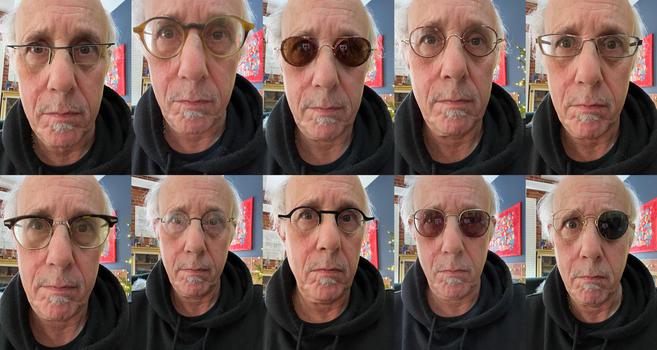 A 2-by-5 grid of ten close-up selfies of an older man with a bald head, wild white hair at the sides, and a white mustache and soul patch, wearing a black hooded sweatshirt. In every shot he looks straight at the camera with raised, slightly furrowed brows and a flat, deadpan expression. Only his glasses change. Behind him is a cozy living room with exposed red brick, a bright red abstract painting on a blue-gray wall, a shelf of small figurines, and holiday lights and greenery.

Top row, left …
